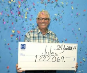 Jules Parent posando con un cheque de utilería en la ciudad de Quebec, Canadá, después de ganar un millón de dólares canadienses en la lotería.