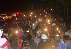 Gente en motocicletas intenta llegar a tierras más elevadas ante el temor de un tsunami luego de un terremoto en Cilazap, centro de Java, Indonesia, el sábado 16 de diciembre de 2017. (AP Foto/Wagino)