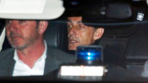 El expresidente francés Nicolas Sarkozy, derecha, sale de la estación de policía en la que estaba detenido, en Nanterre, en las afueras de París, el miércoles 21 de marzo de 2018. (AP Foto/Francois Mori)