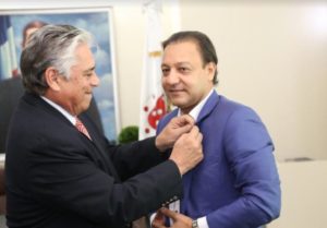 Winston Llenas,coloca el pin de Las Águilas, al alcalde Abel Martínez