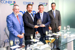 Oscar Peña (centro) al recibir el reconocimiento especial del Conep.